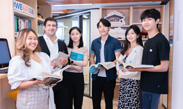 A group of people standing in the University of Sunderland in Hong Kong’s library.