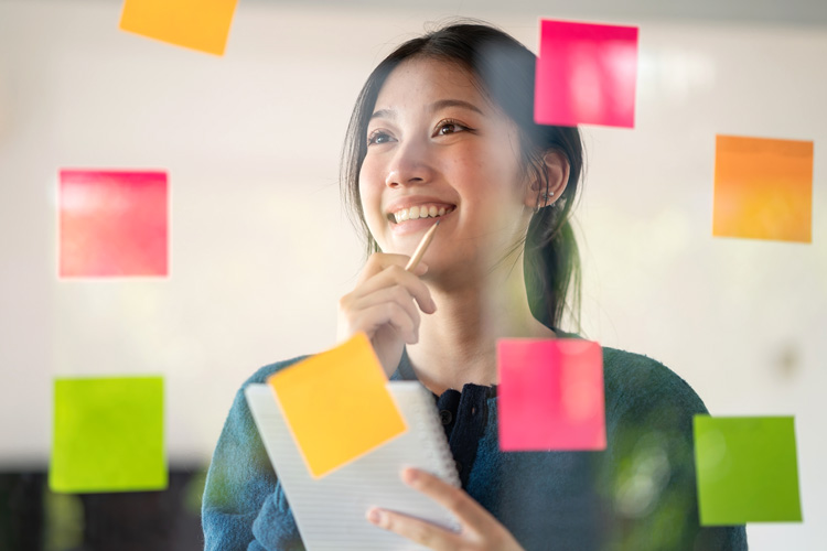 Young confident Businesswoman planning with adhesive notes in creative office.