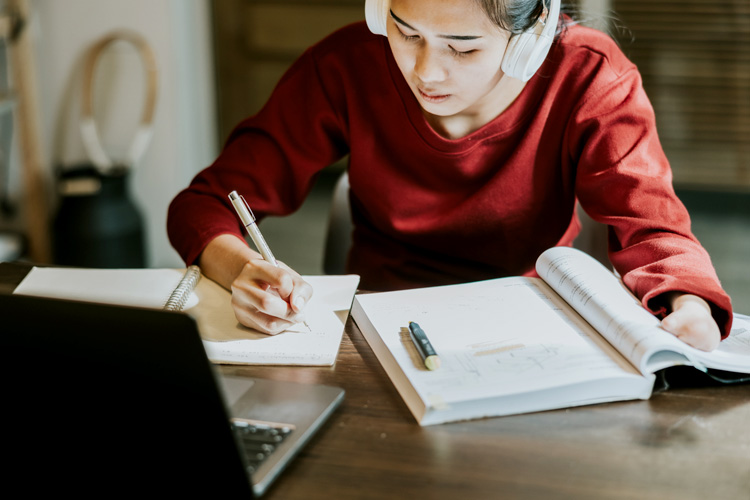 Young Asian woman with hand disability is studying on online class.