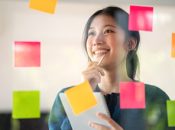 Young confident Businesswoman planning with adhesive notes in creative office.