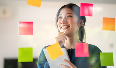 Young confident Businesswoman planning with adhesive notes in creative office.