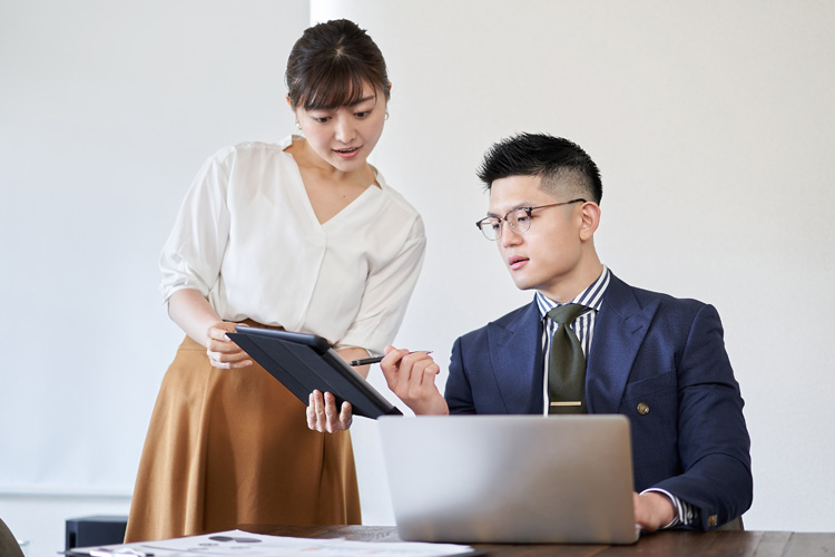 The woman asks the business mentor to review the materials.