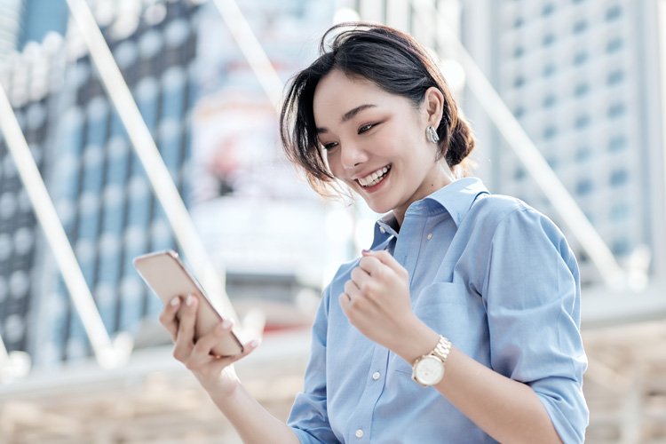 A beautiful Asian businesswoman is looking at her smartphone.