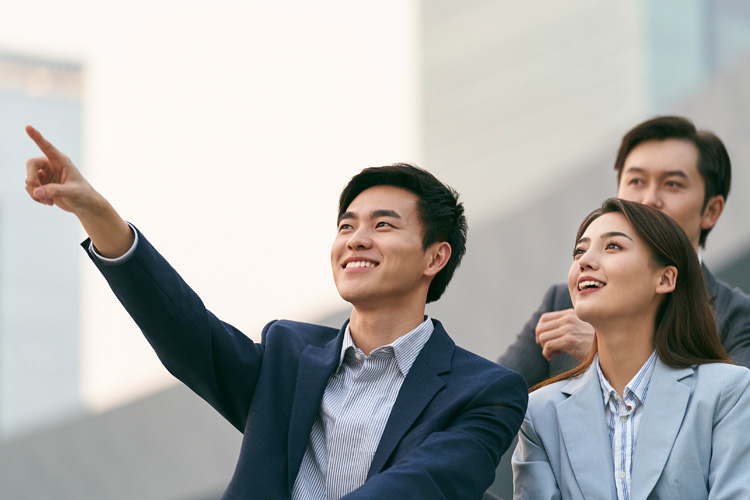 Asian business people enjoying leisure time together outdoors.